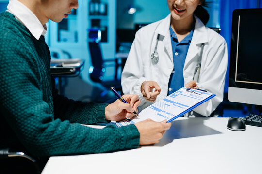 Doctor explains medical form as patient signs consent in modern clinic. Healthcare, insurance, medical consultation, diagnosis, treatment, documentation concept.