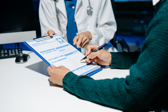 Doctor explains medical form as patient signs consent in modern clinic. Healthcare, insurance, medical consultation, diagnosis, treatment, documentation concept.