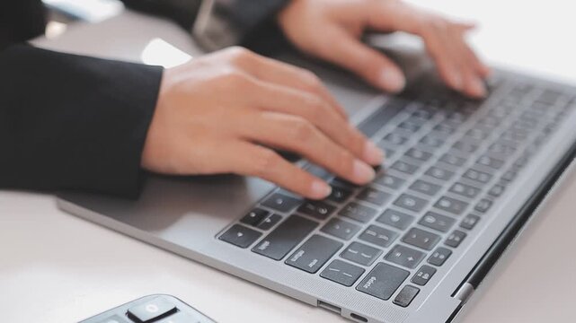 Closeup of the hands of a receptionist typing and sending emails while working in an office alone. One secretary doing admin and writing reports while organizing a schedule for her manager at work