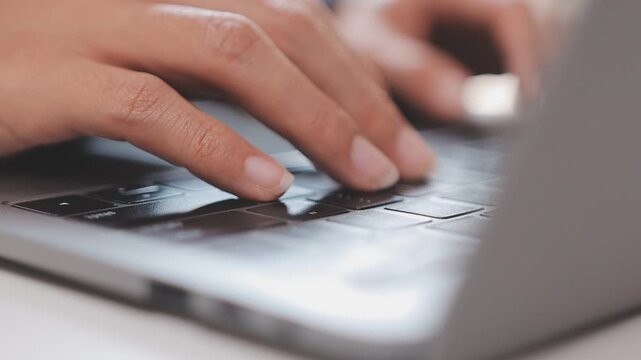 Closeup of the hands of a receptionist typing and sending emails while working in an office alone. One secretary doing admin and writing reports while organizing a schedule for her manager at work