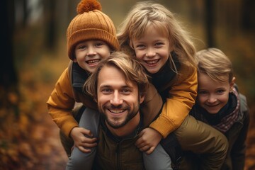 Fototapeta premium Father and three happy children laughing while enjoying a piggyback ride outdoors