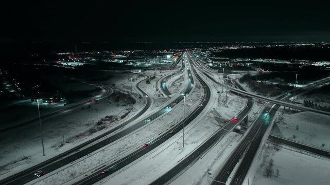 Snowy Mississauga highways at night with light traffic and city lights