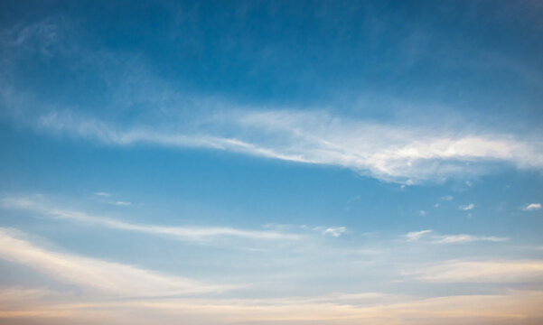 A sky with fluffy white clouds, orange sunlight, apeaceful atmoshere, beautiful and romantic.