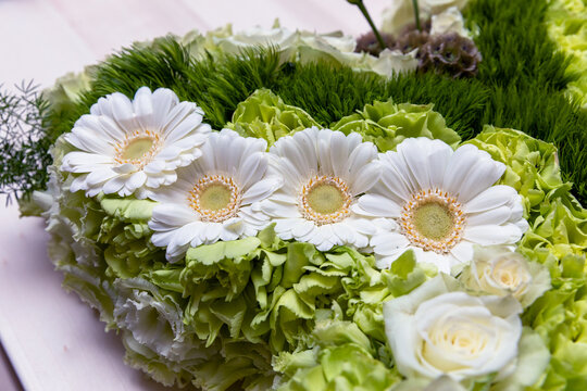 Witte bloemen in een rouwboeket op een kist tijdens een uitvaart