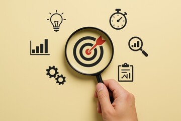 Hand holding magnifying glass over bullseye dartboard surrounded by business icons on beige background symbolizing focus and strategic planning concept. Ai generative