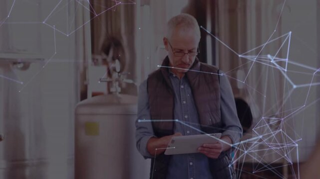 Brew master checking tablet inside brewery, overlaying network lines mapping smart manufacturing