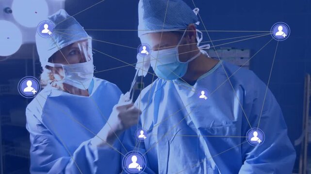 Surgeons raising AR wand and scanning mask, forming animated network overlay for surgery planning