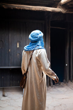 Homme v&ecirc;tu d'un v&ecirc;tement traditionnel et turban bleu dans une ruelle au Maroc