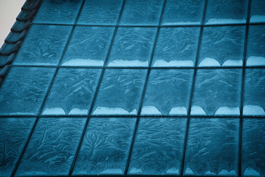 Die mit einer Eisschicht &uuml;berzogenen Paneele einer Solaranlage im Winter