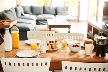 Fototapeta premium Nutrition, pancakes and food on table in home for homemade breakfast, morning meal and protein. Juice, coffee and dining room setup with raspberries for brunch dish, wellness or healthy diet in house