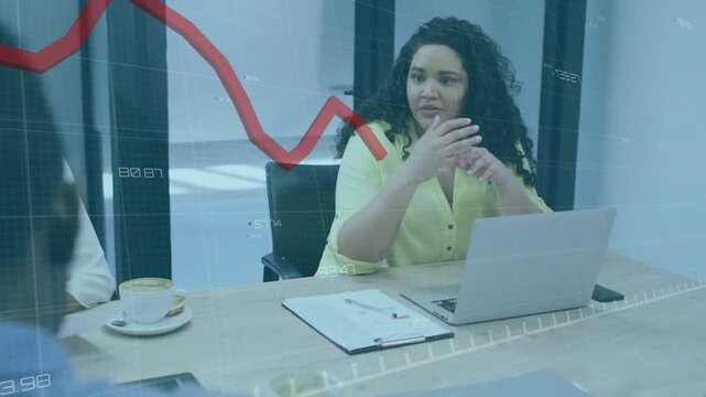 Curly haired woman leaning forward and highlighting transparent red graph overlay business decline