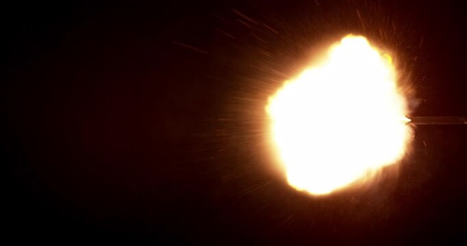 Rapid burst of multiple gun muzzle explosions front view, isolated on black background, real-time speed. Bright fire flashes, sparks and smoke, perfect for VFX compositing.