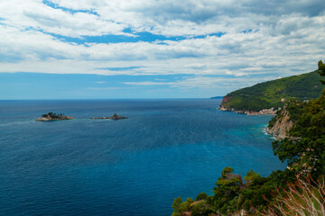 Obraz premium View from top of cliff to beautiful Adriatic seascape near Petrovac, Montenegro. Beautiful coast, rock, and island in sea