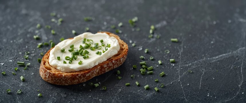 Healthy low fat cream cheese topped with chopped chives on a slice of freshly baked bread, low angle perspective