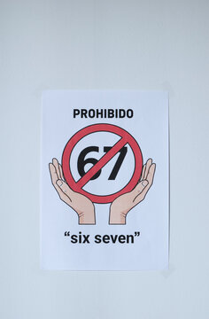 Sign on the white wall prohibition meme phrase six seven  in Spanish