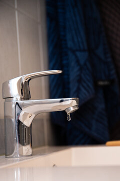 Leaking faucet with single drop falling into sink