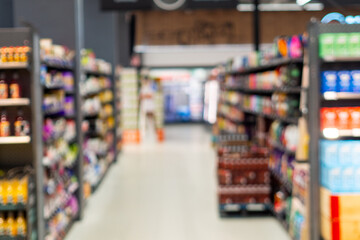 Fototapeta premium Blurry supermarket aisle with colorful products on shelves