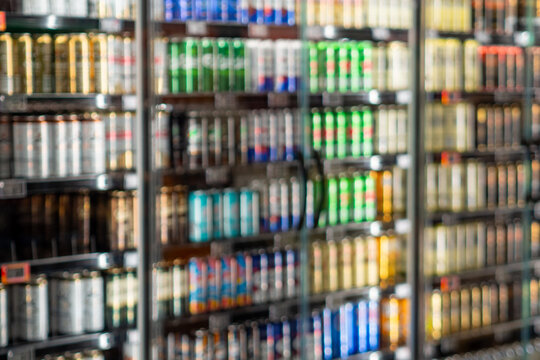 Blurred view of colorful beverage cans on store shelves