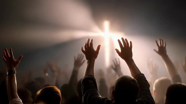 Hands raised in worship towards a glowing cross.