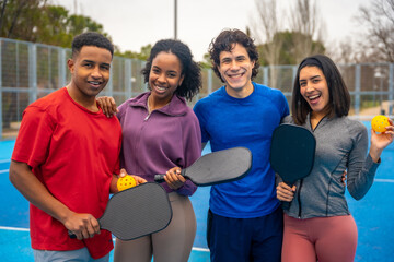 Diverse friends enjoying pickleball on blue court