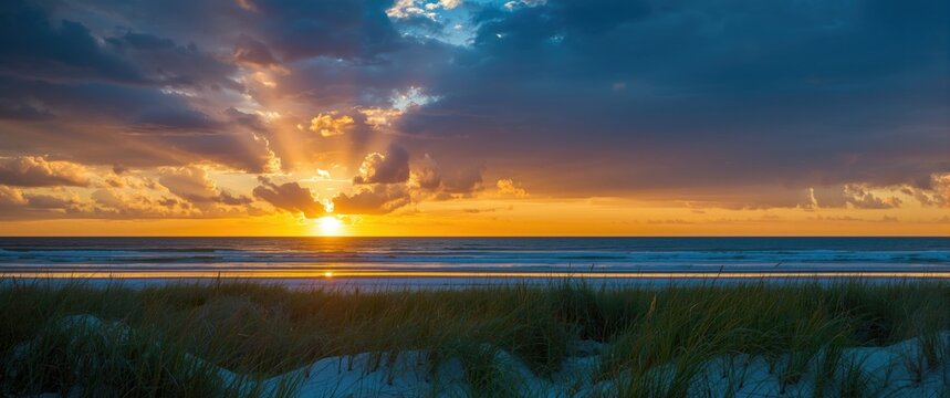 Emerald Coast sunrise in Destin, Florida showcasing dramatic clouds, a golden horizon, and pristine white sandy beaches