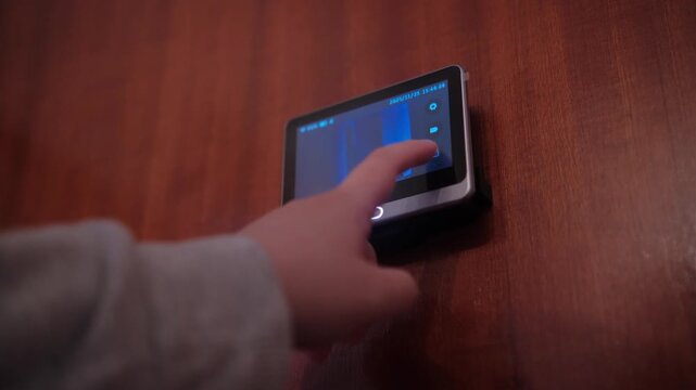 Woman hand adjusting front door peephole security camera. Technology and home secure system concept. 