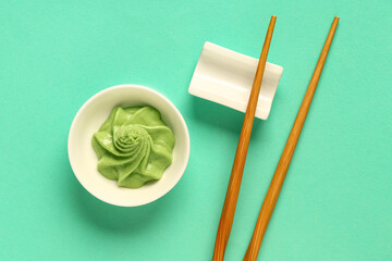 Naklejka premium Bowl with wasabi paste and chopsticks on turquoise background