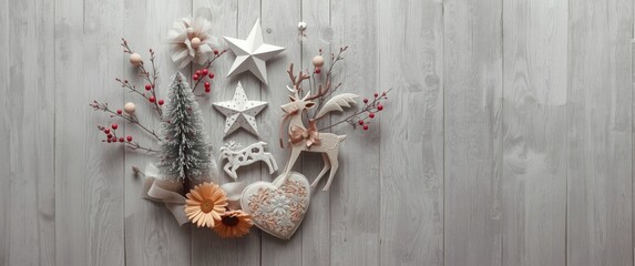 Fototapeta premium Christmas scene with grey wooden backdrop including angel, star, fir tree, reindeer, and heart-shaped ornaments made of white wash wood, embroidery, lace ribbon, gerber daisy, and berries twig
