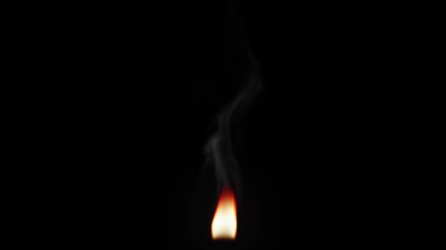 A flickering candle flame with light smoke. Animation of a small fire from a small campfire isolated on a black background.