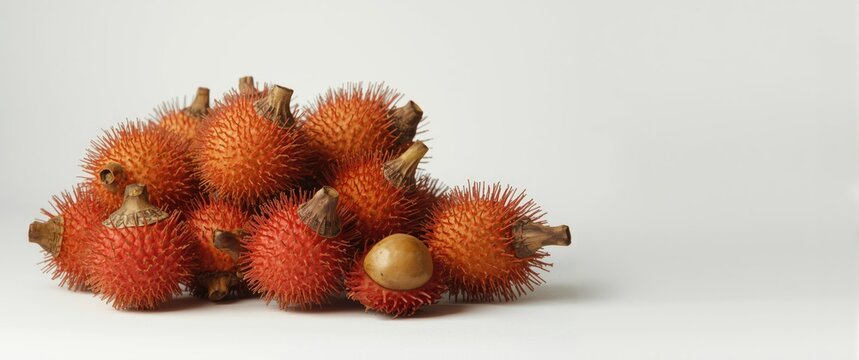 Rambutan on a white background, an Asian fruit accompanied by negrito
