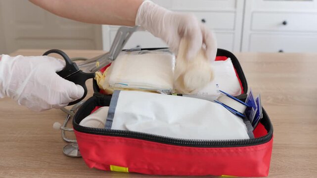 First aid kit in use. Scissors are cutting adhesive tape
