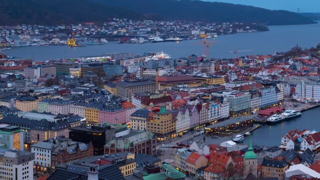 Bergen, Norway. Aerial view of Bergen, Norway at night. Cloudy sunset sky over the city with illuminated roads and car traffic. Time-lapse of Bryggen, panning video