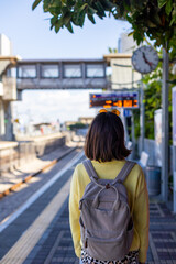 Train passenger. Stylish young woman looks around and waits for the train on the platform.
