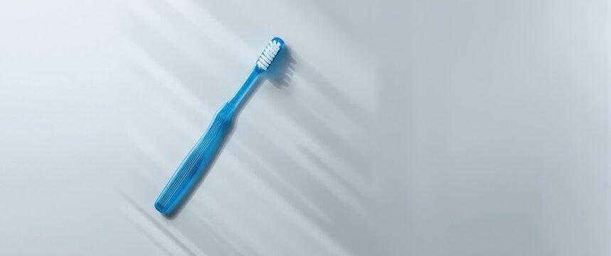 Gray background with a blue plastic toothbrush