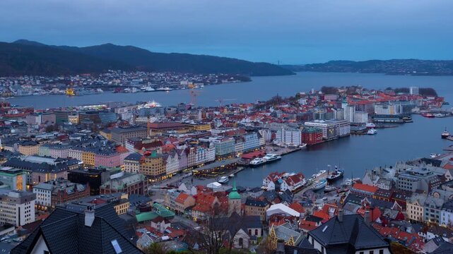 Bergen, Norway. Aerial view of Bergen, Norway at night. Cloudy sunset sky over the city with illuminated roads and car traffic. Time-lapse of Bryggen