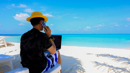 Nomad digital with laptop and running remotely with bright scenic view on the beach in summer time