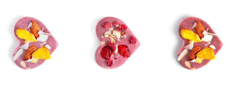 Raw heart shaped chocolate with dried fruits and nuts on a white background. High quality photo