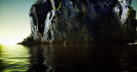 A rugged shoreline stands tall against a serene body of water during dusk. The sunlight casts warm hues on the rock face, creating a peaceful and picturesque coastal setting. © icetray