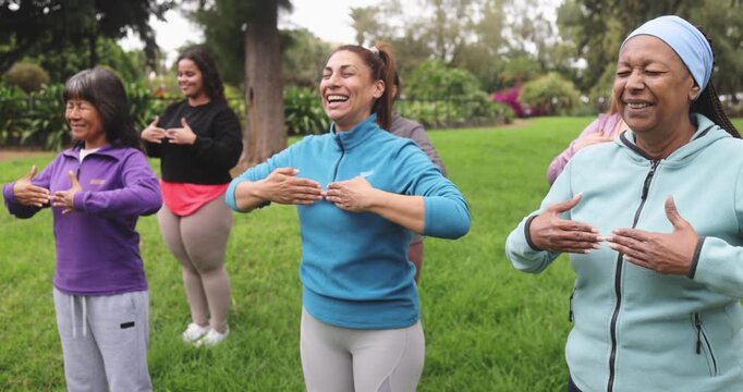Multi generational women doing yoga exercise outdoor - Multiracial female group, healthy lifestyle and diversity concept