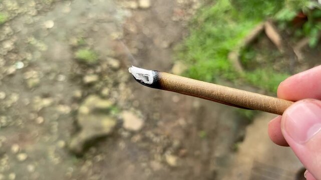 smoking hand-rolled lomboy leaf cigarette outdoors, organic alternative to  tobacco or cannabis, smoke Stock Video
