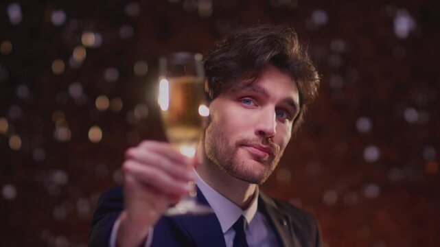 Elegant tuxedo man hold flute glass of champagne. Celebrates success, victory or winnings, wishes you happy new Year or Christmas. Cheers businessman. Handsome mal suit. Celebrate with sparling wine