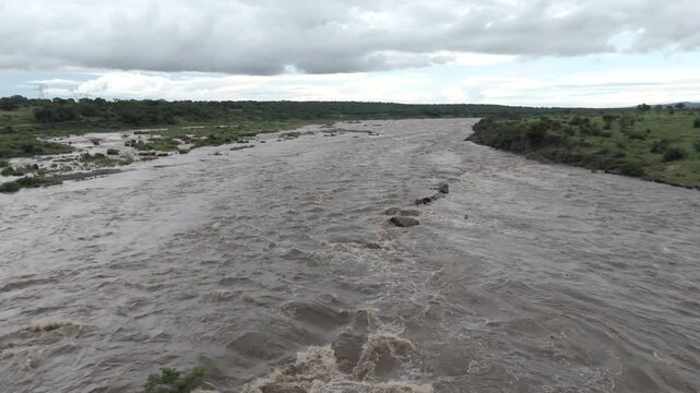 Smooth low-altitude drone footage flying along a flooding river in southern Kruger National Park