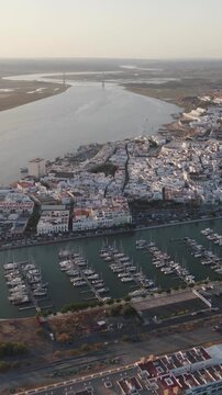 Vertical aerial forward-moving view of the coastal town of Ayamonte, revealing the marina and surrounding waterfront in Andalusia, Spain.