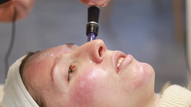 Johvi, Estonia &ndash; December 24, 2026: A woman undergoes an IPL facial cosmetic procedure using light-based aesthetic equipment in a beauty clinic. Real clinical environment during a professional cosmeto