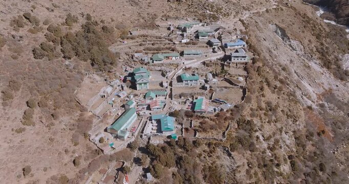 Top-down aerial drone shot revealing Shomare village along the Everest Base Camp route in Nepal. High-altitude settlement with residents, framed by Ama Dablam and Everest views.