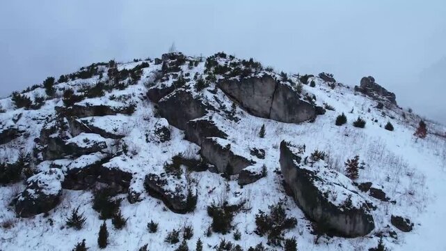 Detailed drone shot of snowy limestone rocks on the summit of Biaklo hill in Poland.