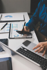 Businesswomen analyzing financial data, discussing investment strategy in office