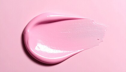 Fototapeta premium A close-up overhead view of a cosmetic product smear on a pink surface, captured from directly above in a studio setting with soft lighting.