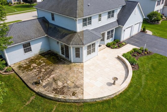Aerial view of residential house showing before and after pressure washing of stone patio and roof