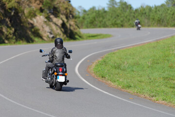 biker on a custom classic motorcycle rides down the road, road traffic